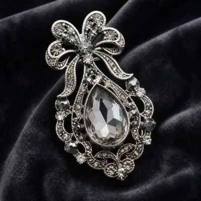 Alfinete gota prateado com cristal transparente em detalhe