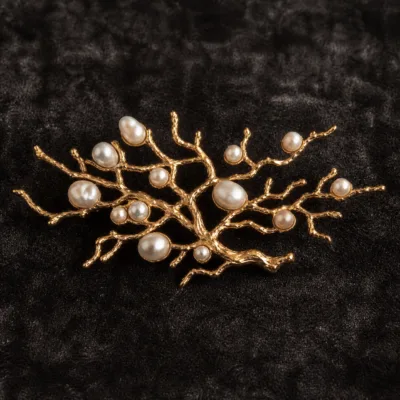 Alfinete ramo dourado com pérolas em detalhe