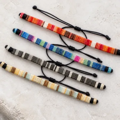 Quatro pulseiras tecidas representativas em cores sortidas