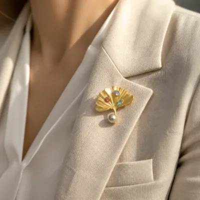 Alfinete folha de ginkgo dourado aplicado numa lapela