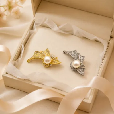 Alfinetes de folhas dourado e prateado numa caixa de joalharia