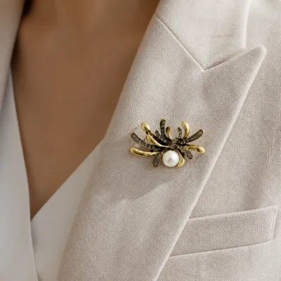 Alfinete aranha dourado com pérola aplicado numa lapela