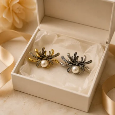 Alfinetes aranha dourado e prateado numa caixa de joalharia