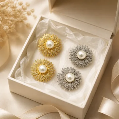 Alfinetes flor radiante dourado e prateado numa caixa de joalharia
