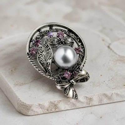 Alfinete oval com pérola cinzenta e cristais rosa