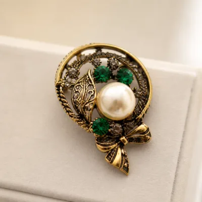 Alfinete oval com pérola marfim e cristais verdes