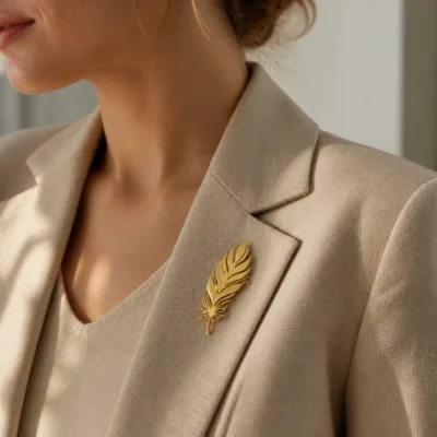 Alfinete de peito dourado em forma de pena numa lapela
