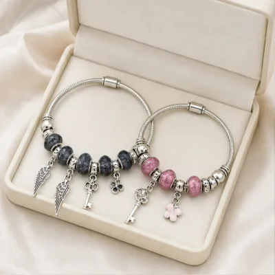 Pulseiras de charms preta e rosa numa caixa de joalharia