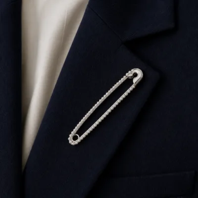 Alfinete prateado com pérolas aplicado num blazer azul-marinho
