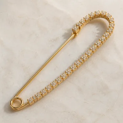 Alfinete de segurança dourado com cristais florais em detalhe