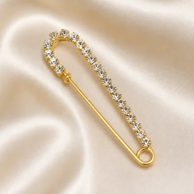 Alfinete comprido dourado com cristais transparentes