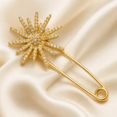 Alfinete dourado com estrela radiante e cristais transparentes