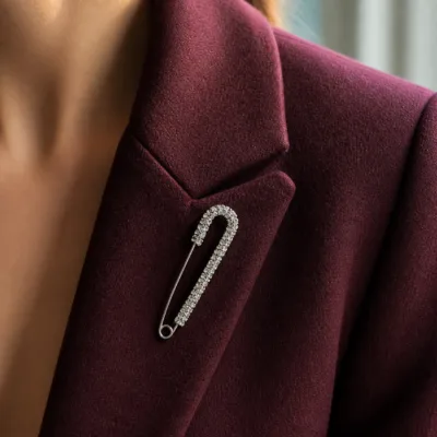 Alfinete largo pavé prateado aplicado num blazer bordô