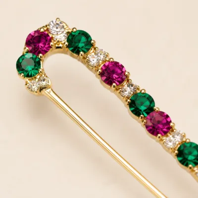 Pormenor dos cristais verdes, rosa e transparentes do alfinete dourado
