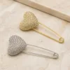 Alfinetes compridos com coração de cristais em dourado e prateado