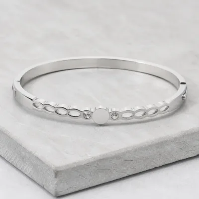 Bracelete prateado com elos ovais sobre pedra clara