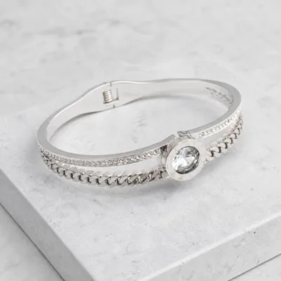 Bracelete prateado com cristais sobre pedra clara