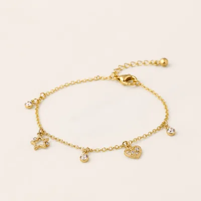 Pulseira dourada com motivos prateados e cristais sobre fundo claro