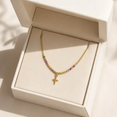 Colar dourado com missangas multicolores em caixa de joalharia