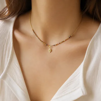 Colar dourado com missangas multicolores usado ao pescoço
