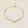 Colar dourado com missangas multicolores sobre fundo claro