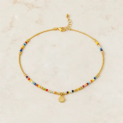 Colar dourado com missangas multicolores sobre fundo claro