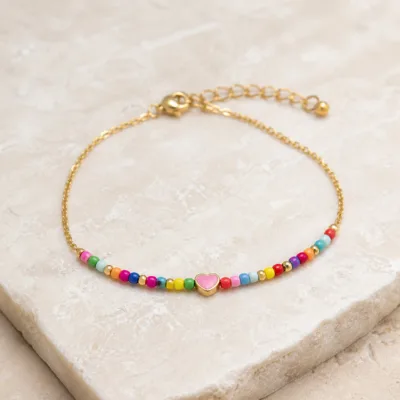 Pormenor das missangas multicolores e pendente e do pendente dourado