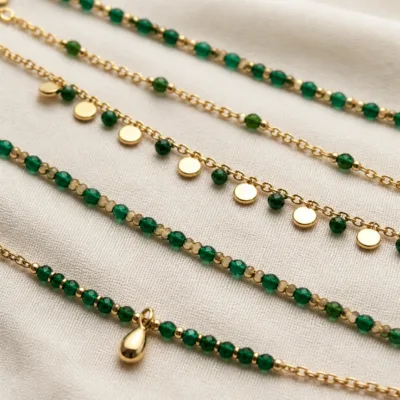 Pormenor das missangas verdes e do pendente dourado