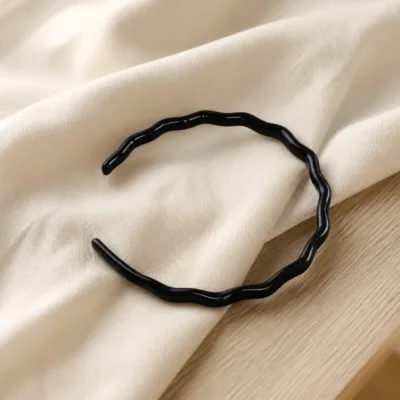 Bandolete preta ondulada num ambiente minimalista com luz natural