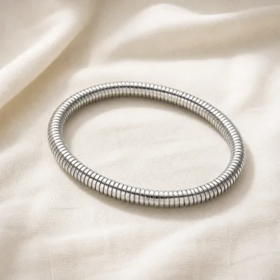 Pulseira flexível prateada sobre linho claro