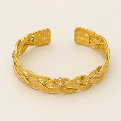 Vista superior do bracelete dourado trançado com acabamento martelado