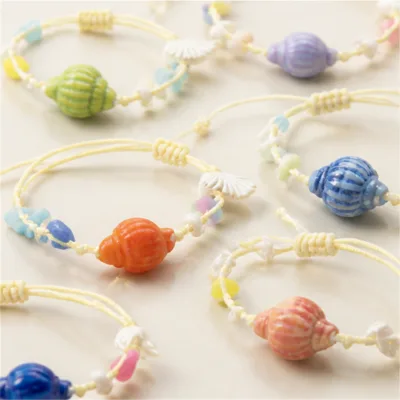 Detalhe das conchas, contas pastel e nós ajustáveis das pulseiras