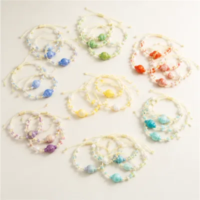 Pulseiras com conchas coloridas organizadas por tom numa composição plana