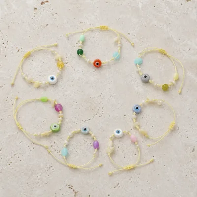 Pulseiras ajustáveis com contas coloridas e olho decorativo em composição plana