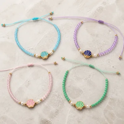 Quatro pulseiras de concha representativas em cores pastel