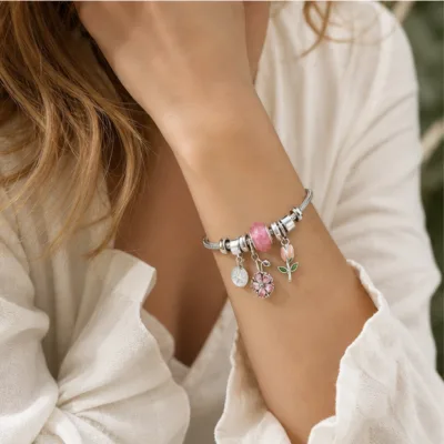 Pulseira de charms florais rosa usada no pulso