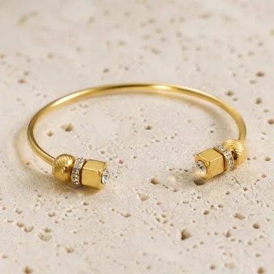 Bracelete Modelo A dourado aberto com terminais geométricos e cristais