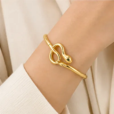 Gold-tone snake-knot bangle 84818 worn on wrist