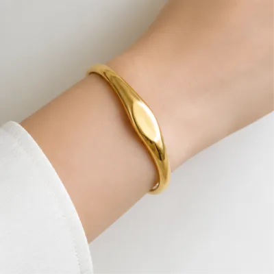 Gold-tone oval centre bangle 84835 worn on wrist
