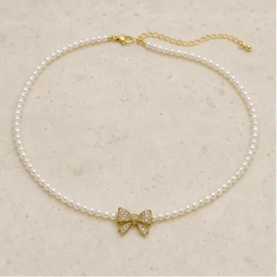 Colar de Pérolas com Laço Brilhante — Dourado
