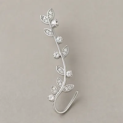 Ear cuff prateado em forma de ramo com folhas e cristais brancos