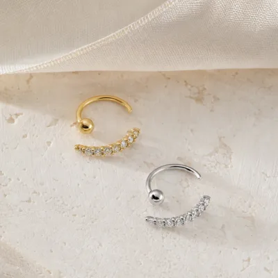 Brincos ear cuff curvos em dourado e prateado com cristais
