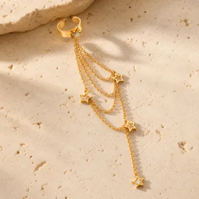 Ear cuff dourado com correntes finas e estrelas vazadas