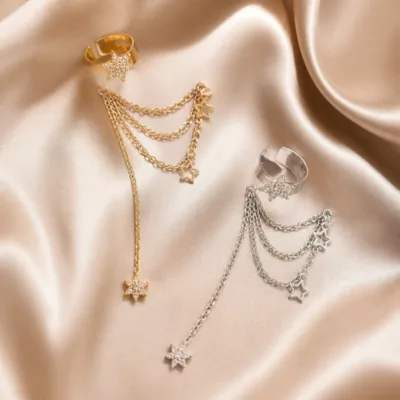 Ear cuffs dourado e prateado com estrelas sobre seda neutra