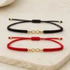 Pulseiras ajustáveis preta e vermelha com símbolo do infinito dourado