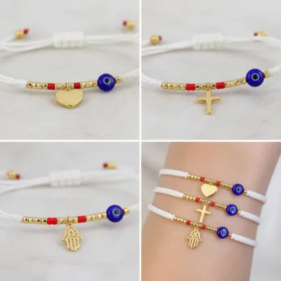 Detalhe dos amuletos dourados e da conta azul protetora