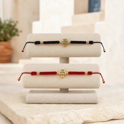 Pulseiras preta e vermelha com Árvore da Vida num expositor