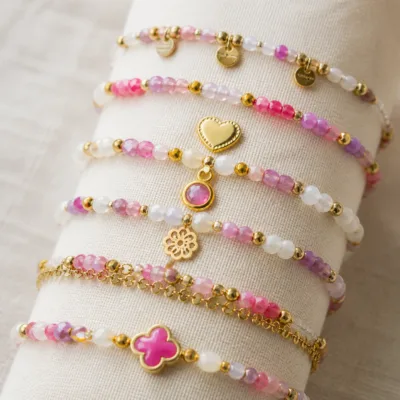Pormenor das missangas rosa, lilás e brancas e do pendente dourado