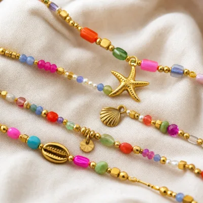 Pormenor das missangas multicolores com motivos marinhos e do pendente dourado