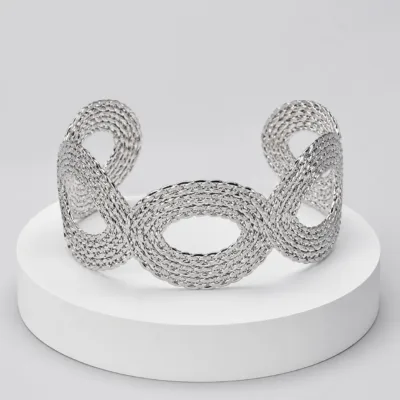 Pulseira larga prateada com elos ovais sobre pedestal
